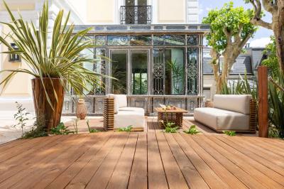 Salle de bain luxueuse avec baignoire en marbre, double vasque, miroirs, et fenêtre donnant sur un jardin.