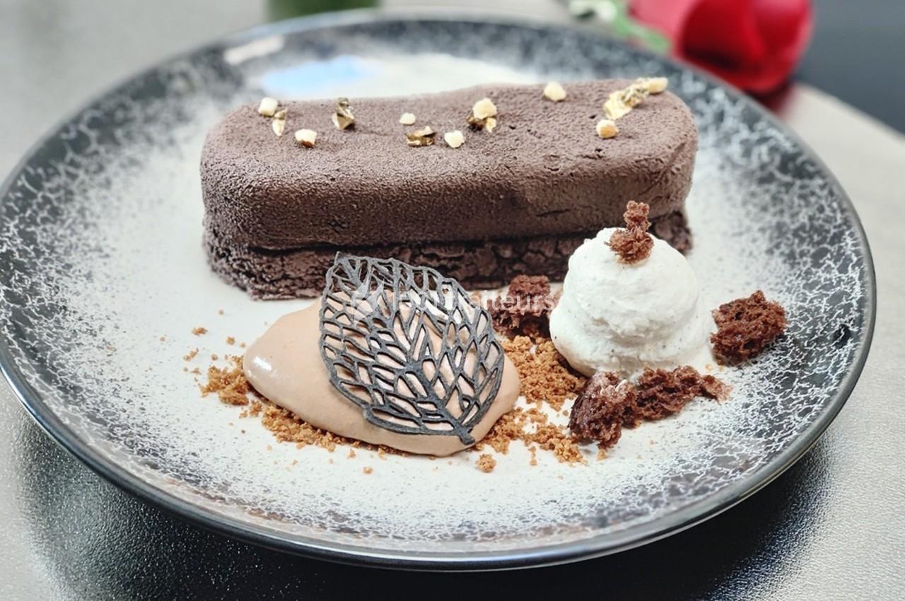 Dessert élégant composé d'un entremets chocolaté, d'une glace, d'une mousse et de décorations en chocolat.