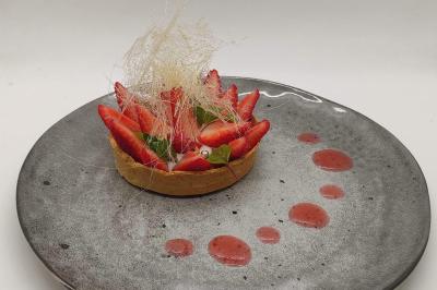 Assiette de burrata garnie de tomates colorées, basilic frais et filet de vinaigre balsamique.