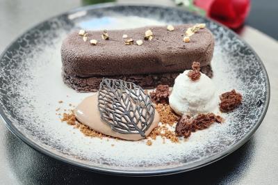 Dessert élégant composé d'un entremets chocolaté, d'une glace, d'une mousse et de décorations en chocolat.