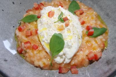 Assiette de burrata garnie de tomates colorées, basilic frais et filet de vinaigre balsamique.