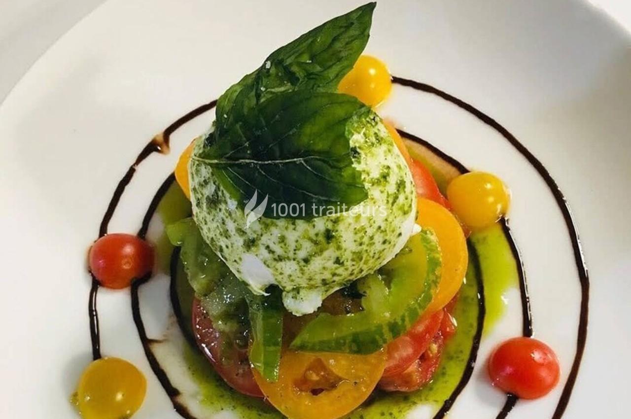 Assiette de burrata garnie de tomates colorées, basilic frais et filet de vinaigre balsamique.