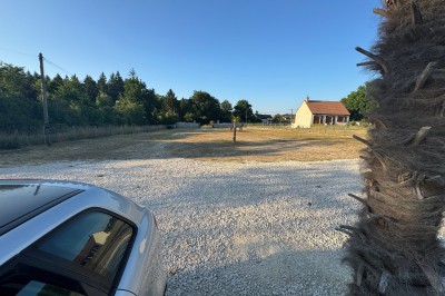 Miniature Location salle Gien (Loiret) - Le Prestigia #15 Structure gonflable colorée sur un sol gravillonné, avec un enfant à proximité et un bâtiment en arrière-plan.
