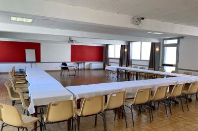 Cuisine moderne avec meubles en bois clair, électroménagers, table blanche et chaises, lave-linge et sèche-linge visibles.