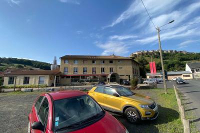 Cuisine moderne avec meubles en bois clair, électroménagers, table blanche et chaises, lave-linge et sèche-linge visibles.