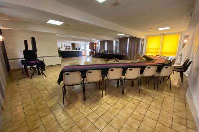 Cuisine moderne avec meubles en bois clair, électroménagers, table blanche et chaises, lave-linge et sèche-linge visibles.