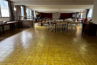 Cuisine moderne avec meubles en bois clair, électroménagers, table blanche et chaises, lave-linge et sèche-linge visibles.