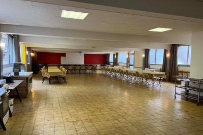 Cuisine moderne avec meubles en bois clair, électroménagers, table blanche et chaises, lave-linge et sèche-linge visibles.