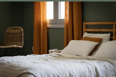 Tentes blanches installées dans une prairie verdoyante entourée d'arbres sous un ciel bleu clair.