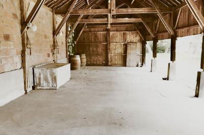 Tentes blanches installées dans une prairie verdoyante entourée d'arbres sous un ciel bleu clair.