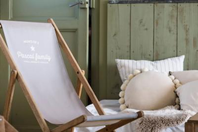 Tentes blanches installées dans une prairie verdoyante entourée d'arbres sous un ciel bleu clair.