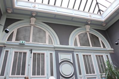 Groupe de personnes discutant et partageant un moment convivial sur une terrasse en soirée, avec des immeubles en arrière…