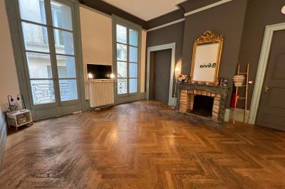 Groupe de personnes discutant et partageant un moment convivial sur une terrasse en soirée, avec des immeubles en arrière…