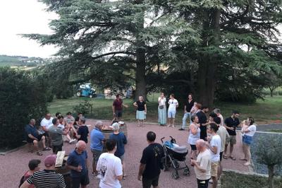 Façade d'un bâtiment en pierre avec de grandes fenêtres, une entrée vitrée et une cour en gravier sous un ciel bleu.