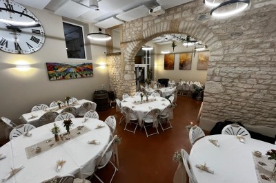 Miniature Location salle Pommiers (Rhône) - Domaine Nicolas Rebut #19 Salle de réception décorée avec des tables rondes dressées, murs en pierre apparente et éclairage chaleureux.