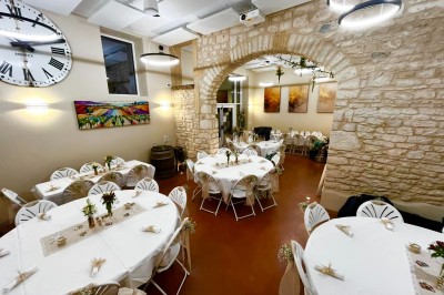 Miniature Location salle Pommiers (Rhône) - Domaine Nicolas Rebut #2 Salle de réception décorée avec des tables rondes dressées, murs en pierre apparente et éclairage chaleureux.