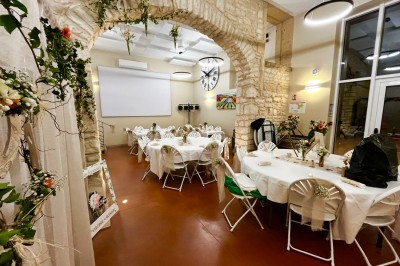 Miniature Location salle Pommiers (Rhône) - Domaine Nicolas Rebut #28 Salle de réception décorée avec des tables rondes dressées, murs en pierre apparente et éclairage chaleureux.