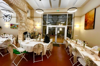Miniature Location salle Pommiers (Rhône) - Domaine Nicolas Rebut #29 Salle de réception décorée avec des tables rondes dressées, murs en pierre apparente et éclairage chaleureux.