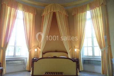 Allée bordée de sacs blancs menant à une tente blanche dans un parc verdoyant par temps ensoleillé.