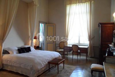 Allée bordée de sacs blancs menant à une tente blanche dans un parc verdoyant par temps ensoleillé.