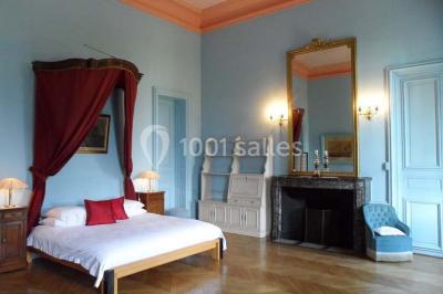 Allée bordée de sacs blancs menant à une tente blanche dans un parc verdoyant par temps ensoleillé.