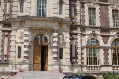 Allée bordée de sacs blancs menant à une tente blanche dans un parc verdoyant par temps ensoleillé.