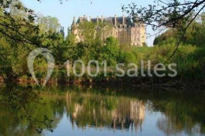 Allée bordée de sacs blancs menant à une tente blanche dans un parc verdoyant par temps ensoleillé.
