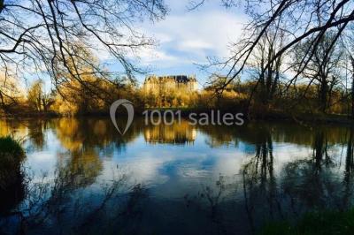 Allée bordée de sacs blancs menant à une tente blanche dans un parc verdoyant par temps ensoleillé.