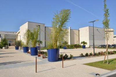 Un couloir d'exposition avec stands éclairés, affiches, et équipements audio sous un plafond voûté en bois.