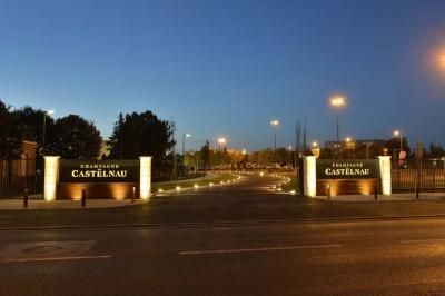 Un couloir d'exposition avec stands éclairés, affiches, et équipements audio sous un plafond voûté en bois.
