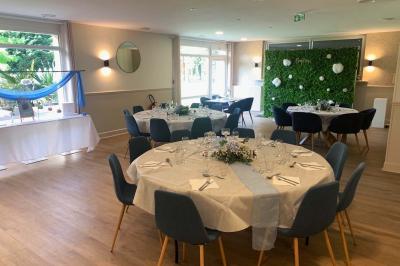 Terrain de pétanque miniature avec tapis bleu, entouré d'herbe, et boules rangées dans des supports aux extrémités.