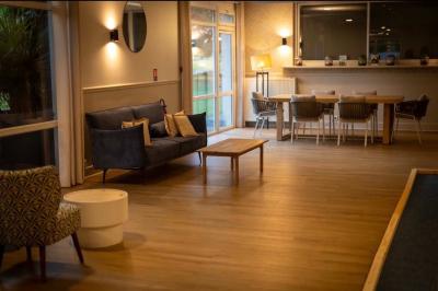 Terrain de pétanque miniature avec tapis bleu, entouré d'herbe, et boules rangées dans des supports aux extrémités.