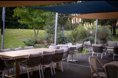 Terrain de pétanque miniature avec tapis bleu, entouré d'herbe, et boules rangées dans des supports aux extrémités.