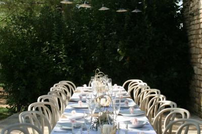 Salon lumineux avec canapé turquoise, coussins colorés, télévision, tapis en fibres naturelles et vue sur une cuisine…