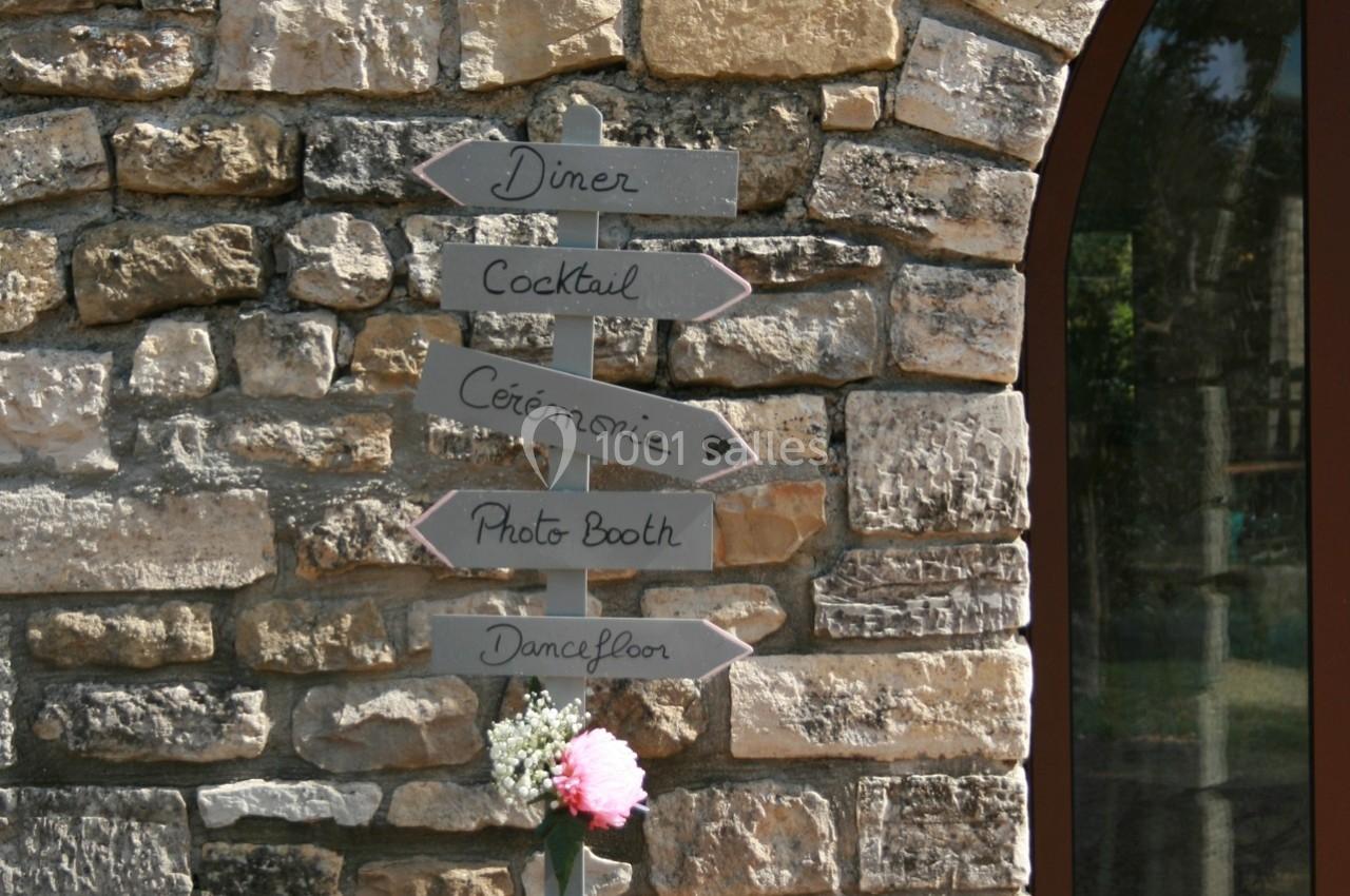 Panneau en bois indiquant les directions pour un dîner, cocktail, cérémonie, photo booth et piste de danse, fixé sur un mur…