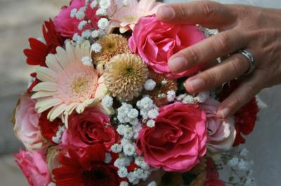 Salon lumineux avec canapé turquoise, coussins colorés, télévision, tapis en fibres naturelles et vue sur une cuisine…