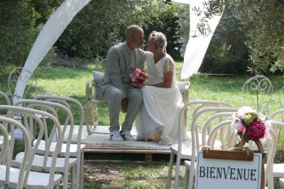 Salon lumineux avec canapé turquoise, coussins colorés, télévision, tapis en fibres naturelles et vue sur une cuisine…