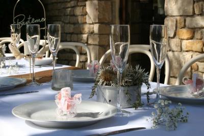 Salon lumineux avec canapé turquoise, coussins colorés, télévision, tapis en fibres naturelles et vue sur une cuisine…