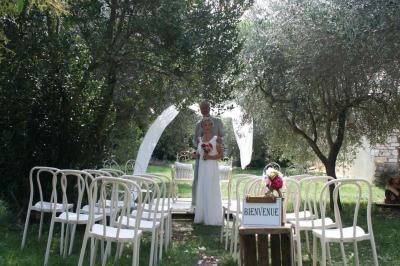 Salon lumineux avec canapé turquoise, coussins colorés, télévision, tapis en fibres naturelles et vue sur une cuisine…