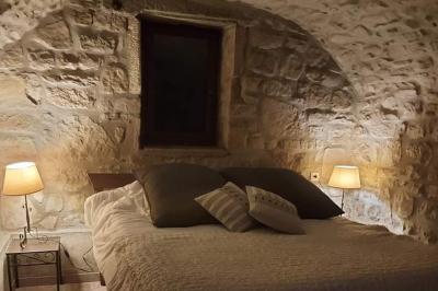 Salon lumineux avec canapé turquoise, coussins colorés, télévision, tapis en fibres naturelles et vue sur une cuisine…