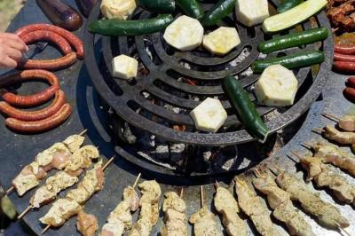 Salon lumineux avec canapé turquoise, coussins colorés, télévision, tapis en fibres naturelles et vue sur une cuisine…