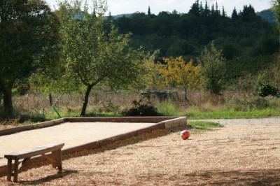 Salon lumineux avec canapé turquoise, coussins colorés, télévision, tapis en fibres naturelles et vue sur une cuisine…
