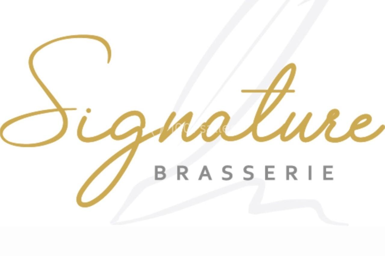 Logo de la brasserie ’Signature’ avec une écriture élégante dorée et grise, sur fond blanc avec un motif de plume.