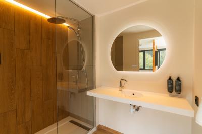 Lit avec des draps blancs, serviettes pliées au premier plan et mur décoré de branches et papillons colorés.