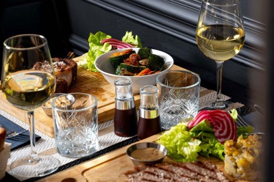 Logo du restaurant ’Le Bouche à Oreille’ avec des motifs floraux dorés sur fond noir.