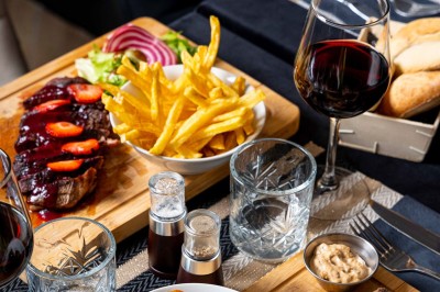 Logo du restaurant ’Le Bouche à Oreille’ avec des motifs floraux dorés sur fond noir.