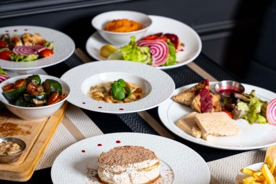 Logo du restaurant ’Le Bouche à Oreille’ avec des motifs floraux dorés sur fond noir.