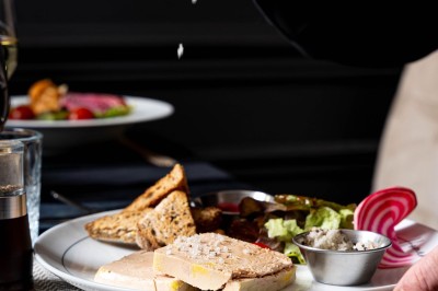 Logo du restaurant ’Le Bouche à Oreille’ avec des motifs floraux dorés sur fond noir.