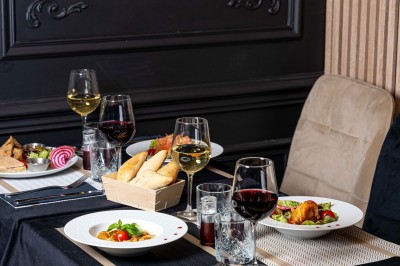 Logo du restaurant ’Le Bouche à Oreille’ avec des motifs floraux dorés sur fond noir.