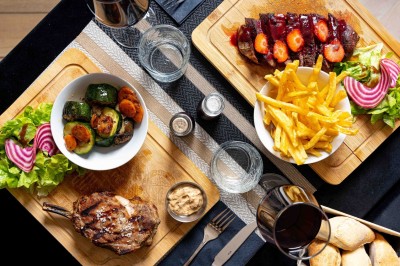 Logo du restaurant ’Le Bouche à Oreille’ avec des motifs floraux dorés sur fond noir.
